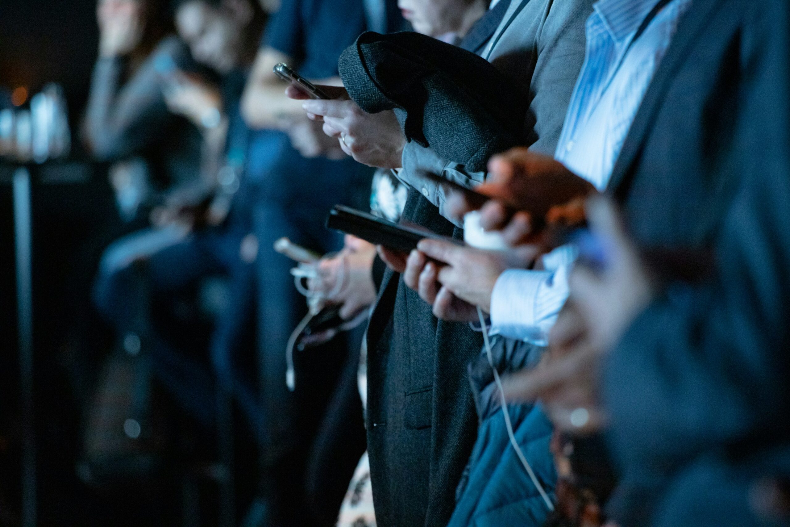 Shot of people handling their mobile devices as a symbol for over stimulation