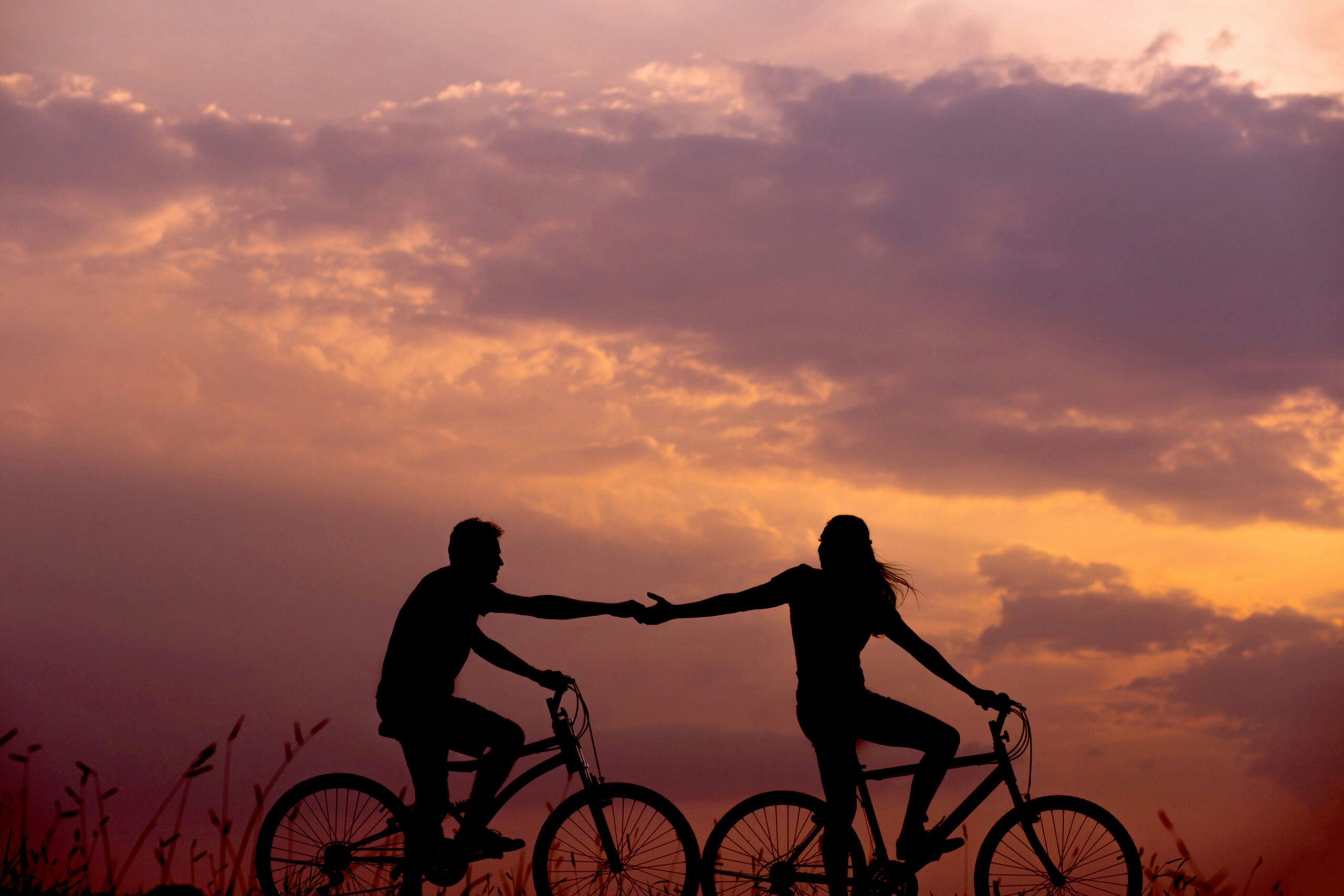 Silhouette of a couple on a bike