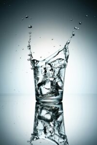 Detail shot of a glass of water with ice cubes to symbolise hydration