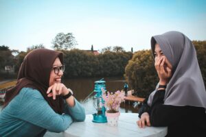 Two female figures sitting across each other and talking