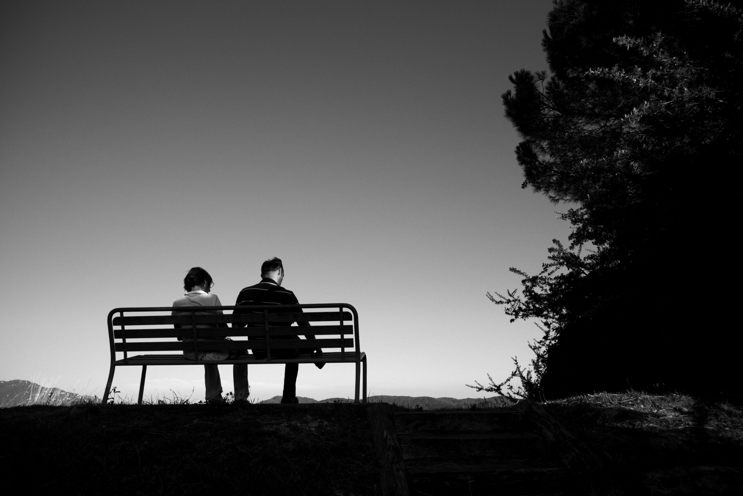 Silhouette of a couple on a bench as a symbol for leaving a harmful relationship